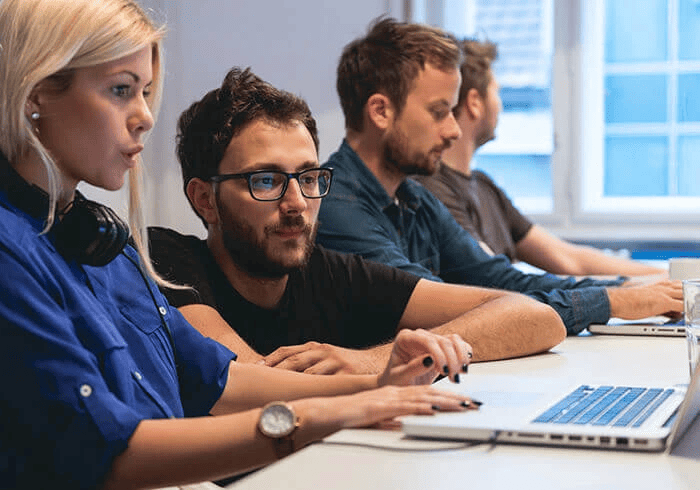 A female and male discussing something on laptop