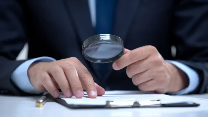 man looking at a piece of paper with a magnifier