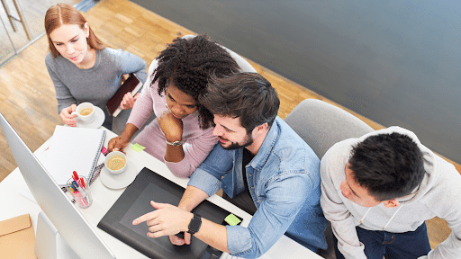 A team of developers collaborating on a Visual LANSA project in a modern office